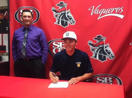 John Jensen signs for his scholarship to UC Irvine as athletic director Rocco Constantino looks on.